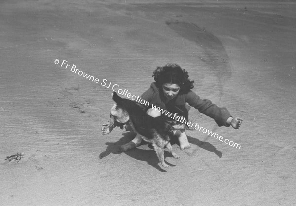 GIRL PLAYING WITH DOG ON BEACH